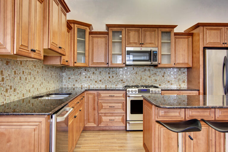Cabinetry Brands 27 NEA Trading kitchen with glazed maple raised-panel cabinets and dark granite countertops