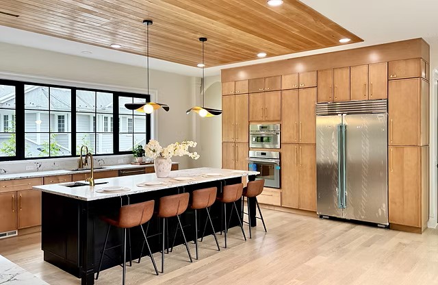 Cabinetry Brands 21 Wood Concept kitchen with light wood cabinets, a black island and a wood ceiling