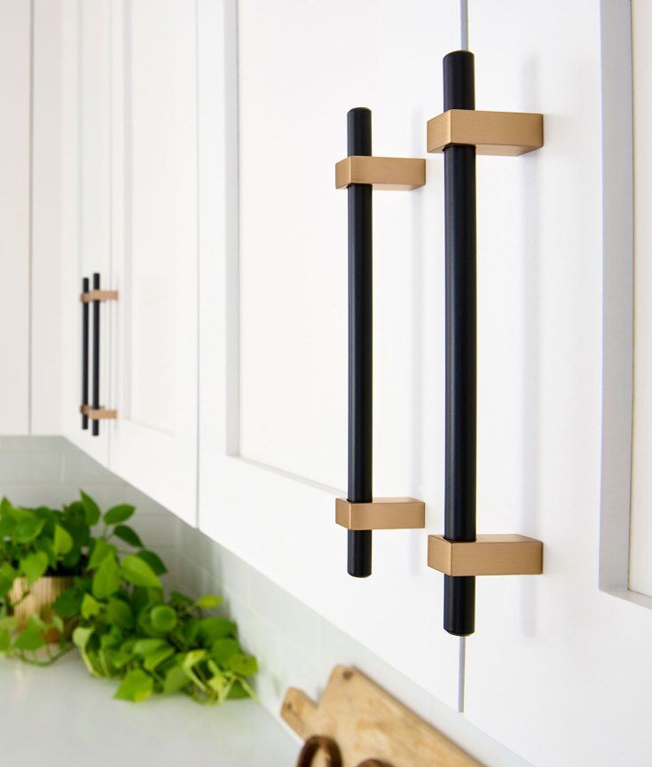 Black and brass bar pulls on white shaker kitchen cabinets