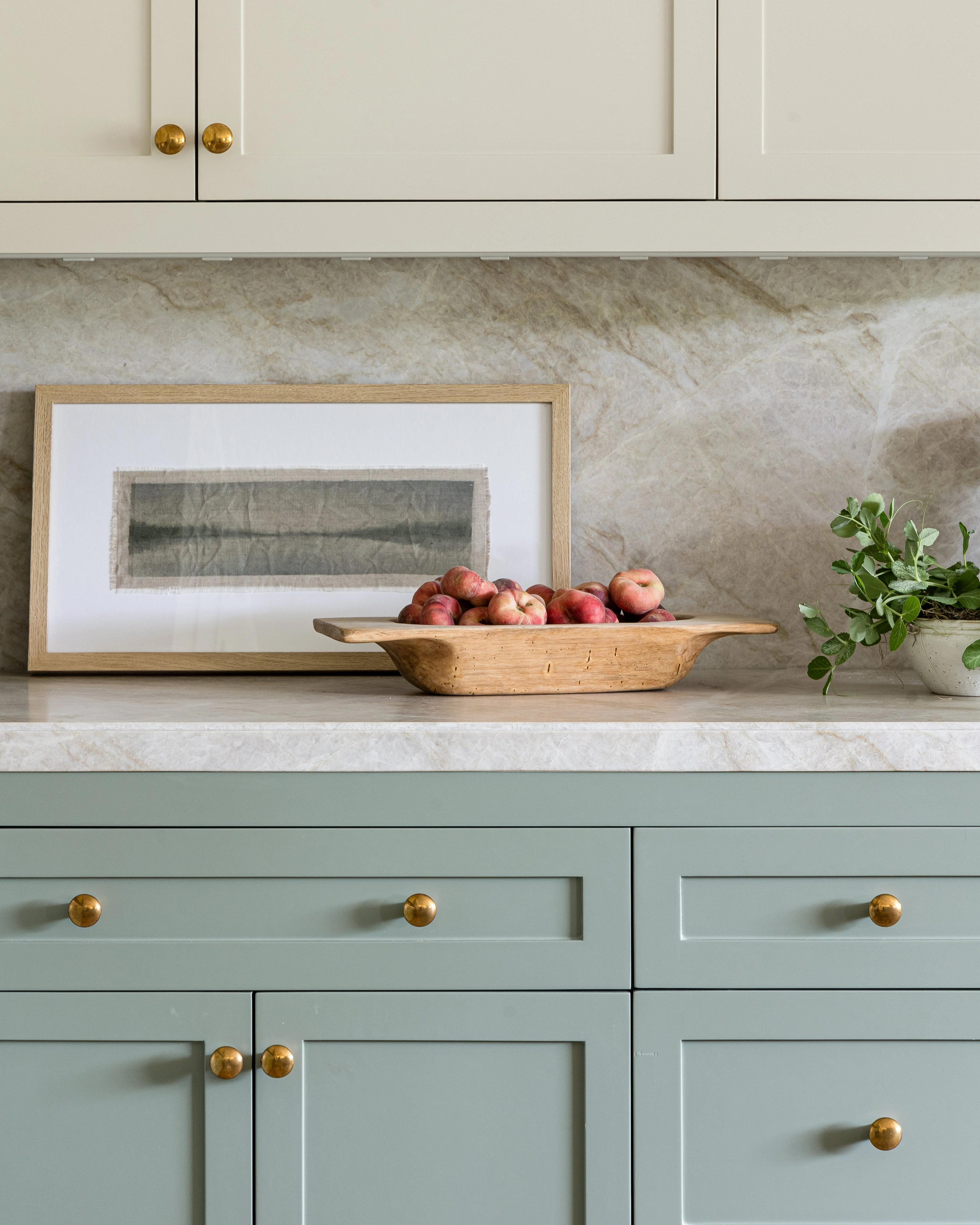 Champagne bronze bar pulls with ribbed ends on white shaker drawers under a dark stone countertop