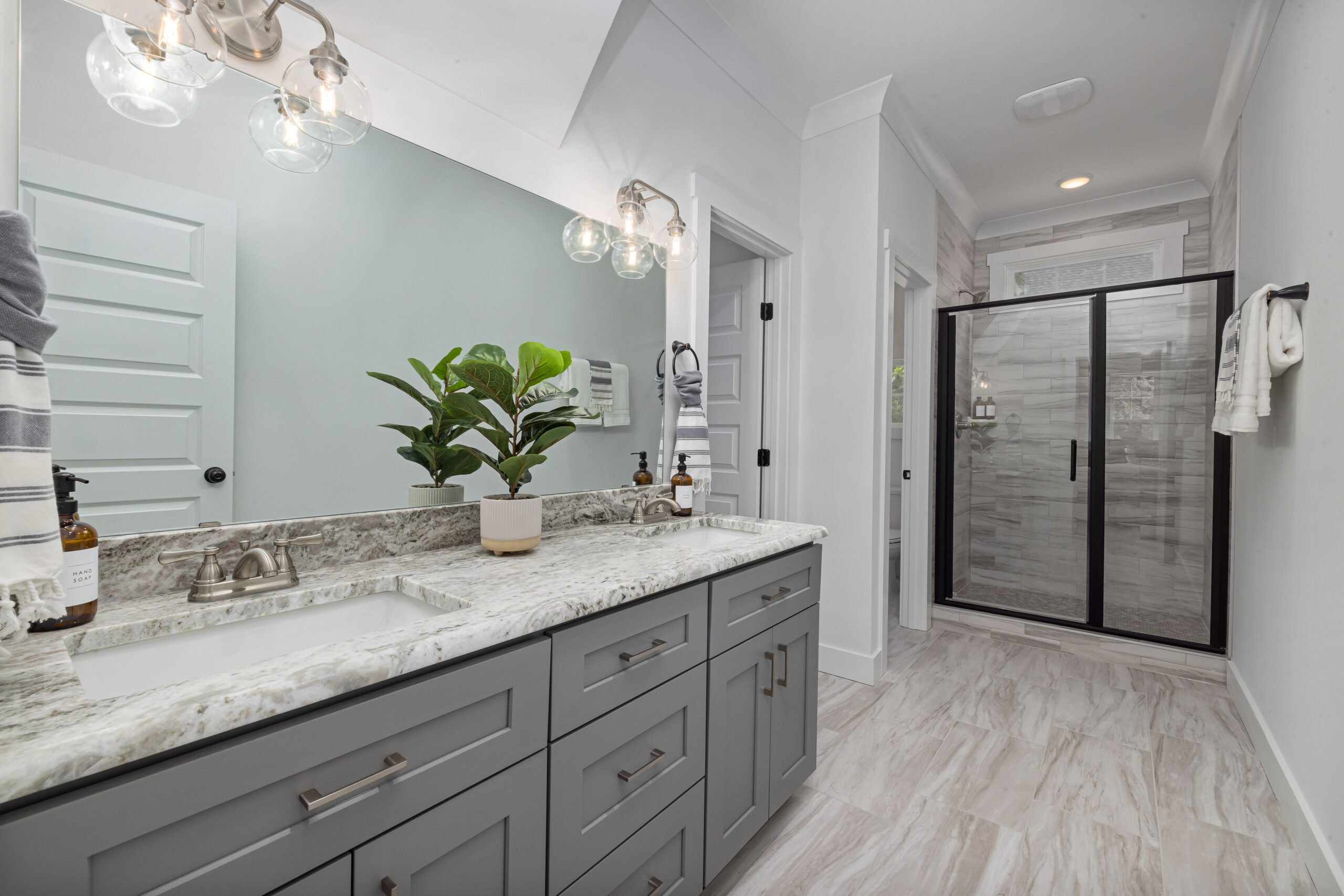 Gray shaker double bathroom vanity with black hardware and a white top