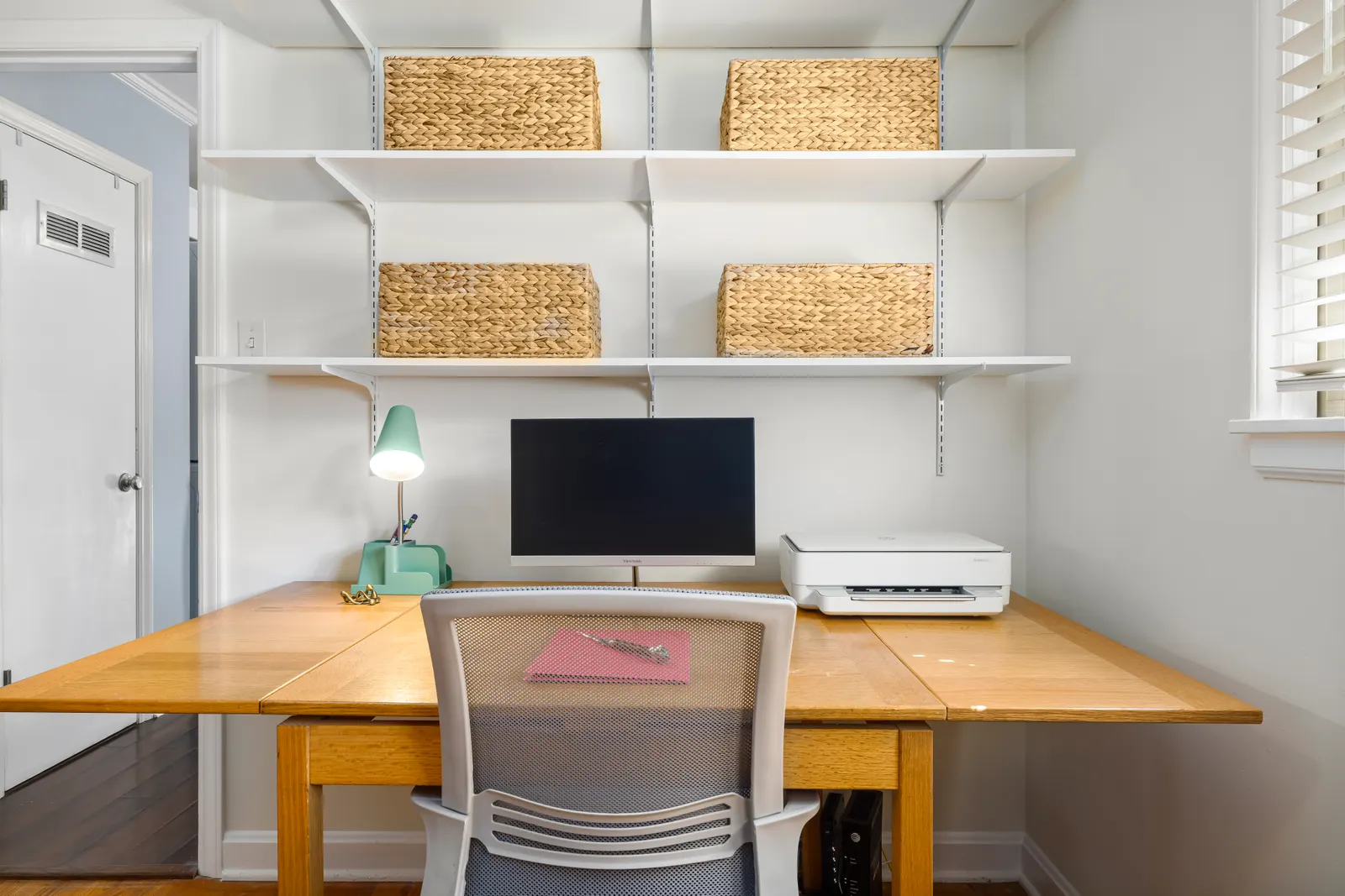 Home Office Cabinets 5 Home office with a long wood desk under open wall shelves and storage baskets