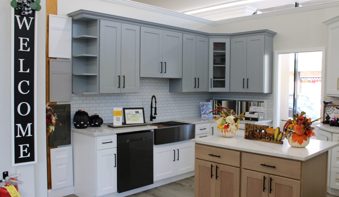 Granite vs. Quartz vs. Laminate Countertops: Which Is Right for Your New Jersey Kitchen? 1 Gray and white kitchen cabinets with a wood island and white countertops at the Kitchen Factory Newark showroom