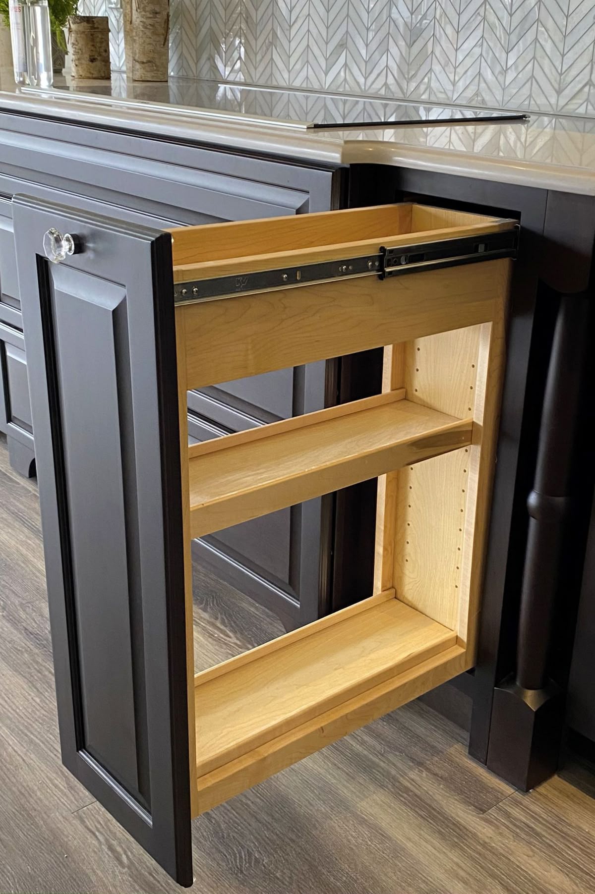 Narrow pull-out base cabinet organizer with wood shelves in dark cabinets