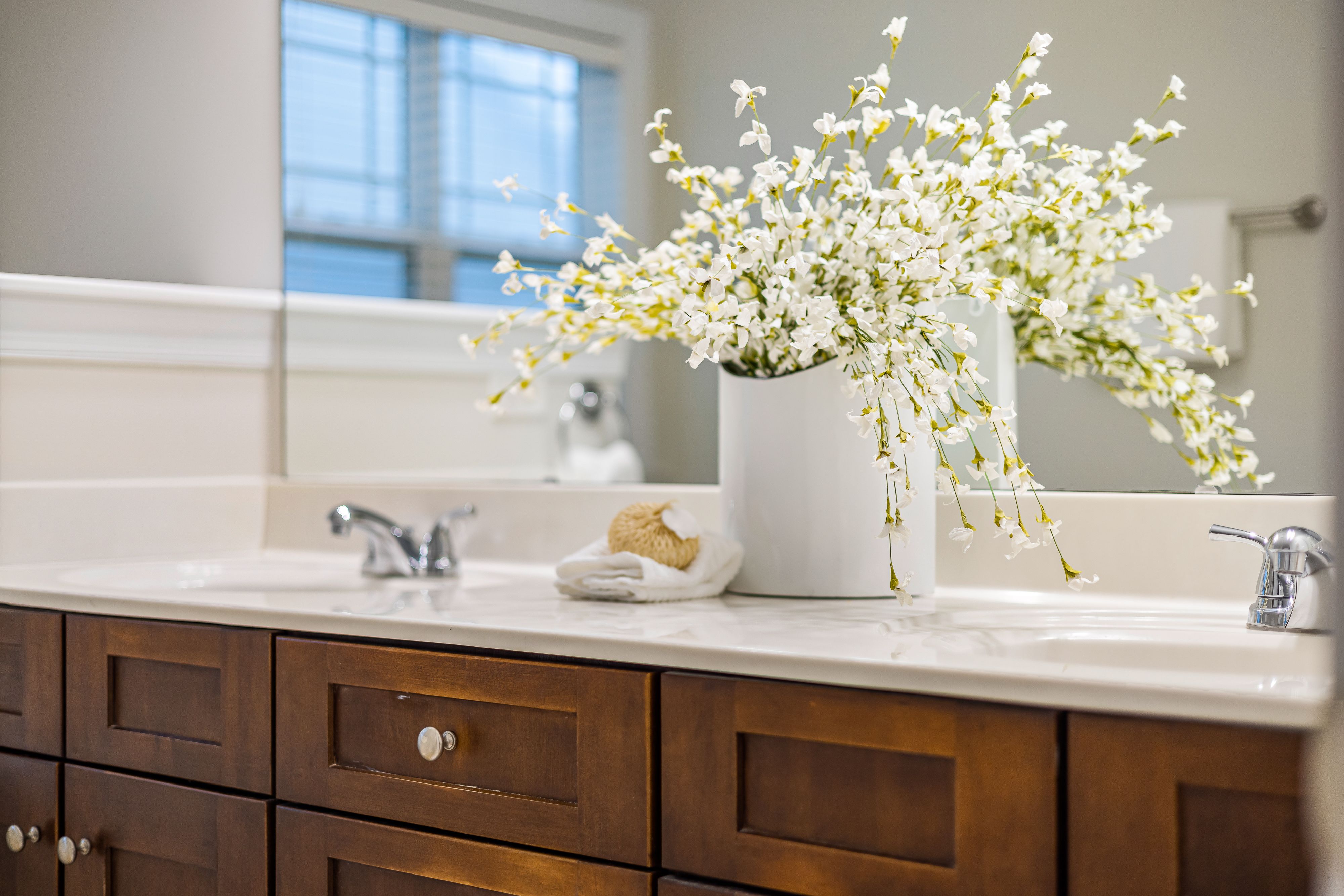 White granite double vanity countertop with tulips in a glass vase