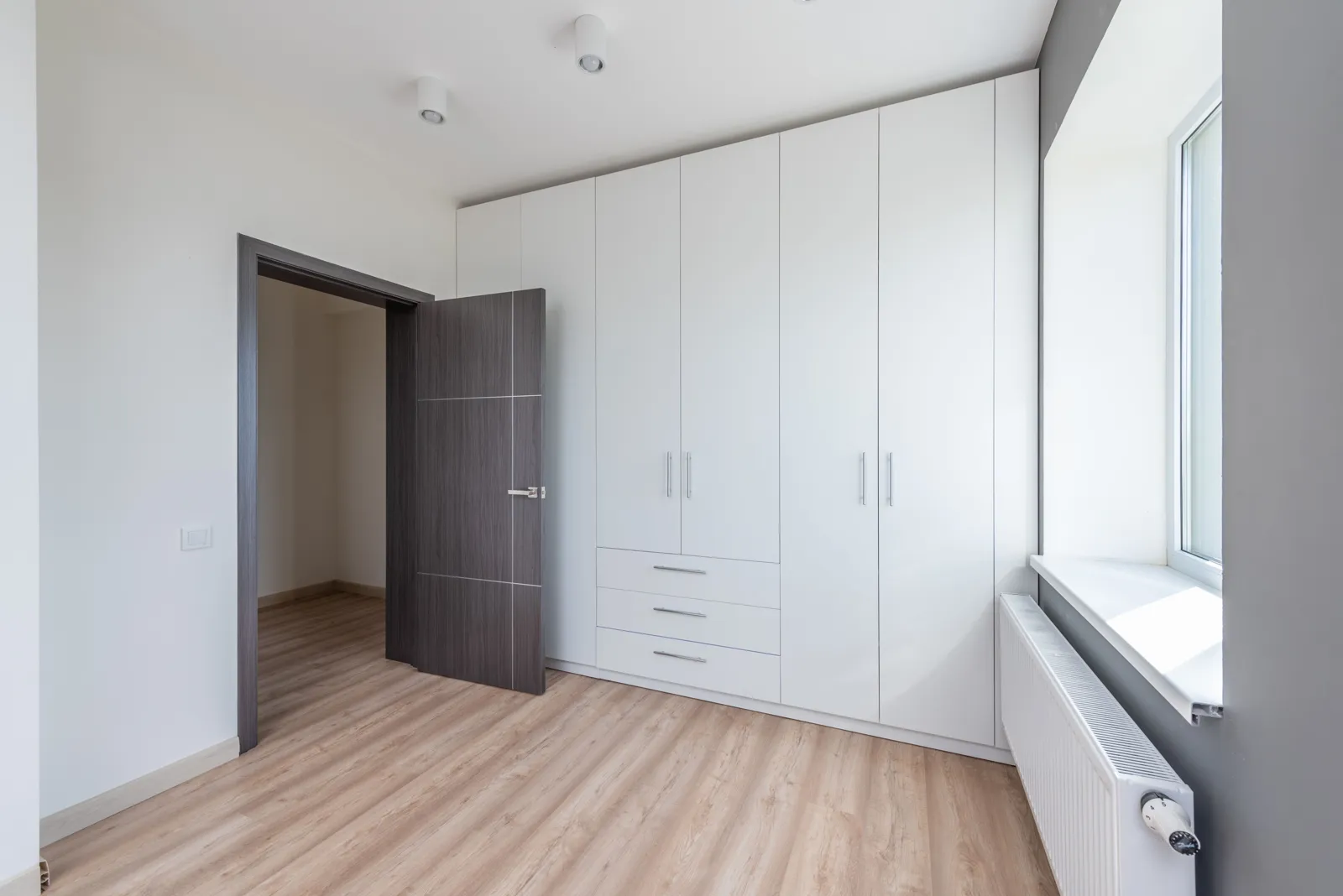 Custom Closets 3 White reach-in wardrobe with drawers along a bedroom wall