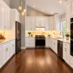 White shaker kitchen with a dark hardwood floor, wall ovens and a backlit backsplash