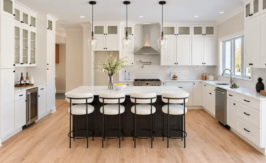 White shaker kitchen with an espresso island, four white stools and a stainless range hood