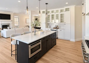 Espresso kitchen island with a white veined countertop, built-in microwave drawer and glass pendant lights