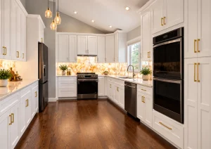 Tall white cabinets with built-in black wall ovens and long gold handles