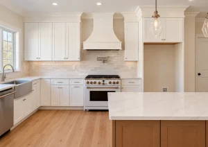 White range hood and shaker cabinets above a professional-style range, with a farmhouse sink under the window