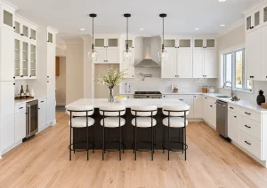 White shaker kitchen with an espresso island, four white stools and a stainless range hood